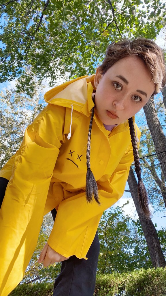 Jazz is wearing the sad raincoat while leaning forward looking down on the camera